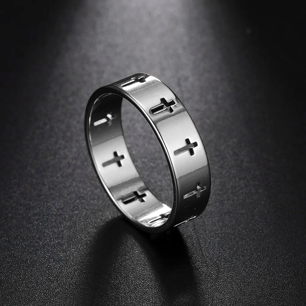 Silver ring with cross designs on a dark textured background